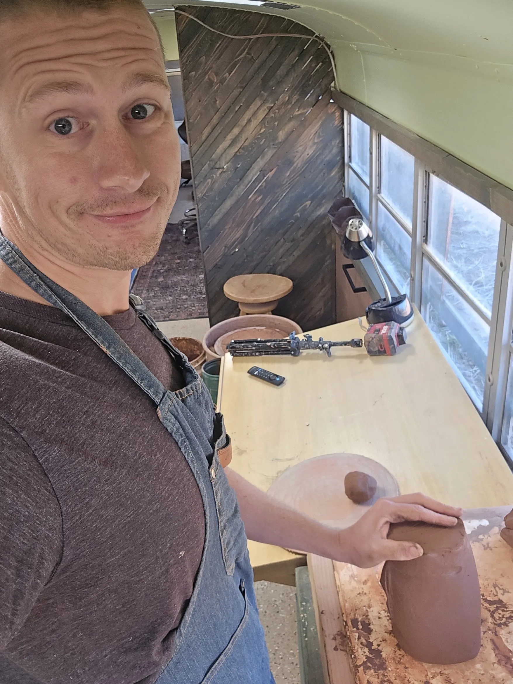 Richard Ward at work at a table inside the bus studio