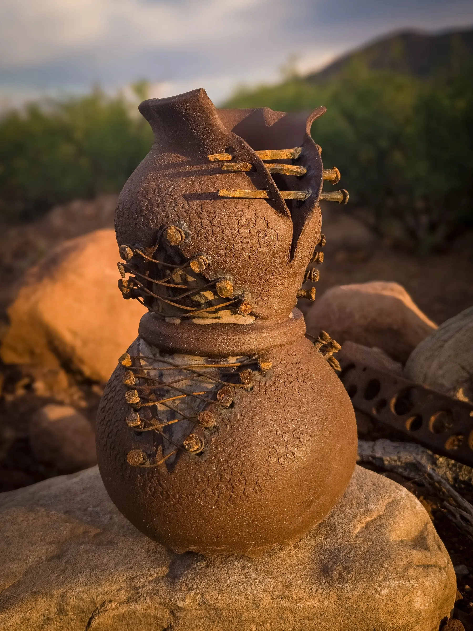 A Rust Becoming sculpture with lace-textured clay and rusted nails, seen from another side